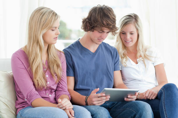 trzy osoby zwracają uwagę na tablet przed nimi - digital tablet young men women short hair zdjęcia i obrazy z banku zdjęć