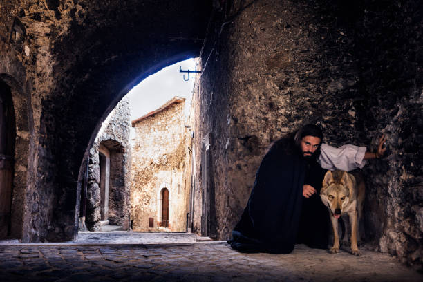 Medieval scene man and wolf Man and a wolf in an mysterious ancient sporti, one of nine tunnels in the fortified medieval village of Castel del Monte in Gran Sasso National Park, L'Aquila province, Abruzzo, Italy, Europe suspenseful stock pictures, royalty-free photos & images