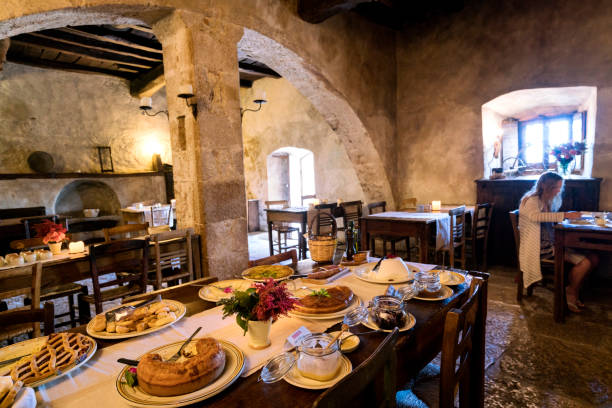 Blond teenage girl eats breakfast in the ancient arched dining room in the diffused hotel of Santo Stefano di Sextantio, in the medieval fortified village of Santo Stefano di Sessanio; Gran Sasso National Park; L'Aquila Province, Abruzzo; Italy; Europe adolescente rubia come el desayuno en el antiguo comedor abovedado en el hotel difuso de santo stefano di sextantio, en pueblo medieval fortificado de santo stefano di sessanio; parque nacional de gran sasso; provincia de l'aquila, abruzzo; italia; europa