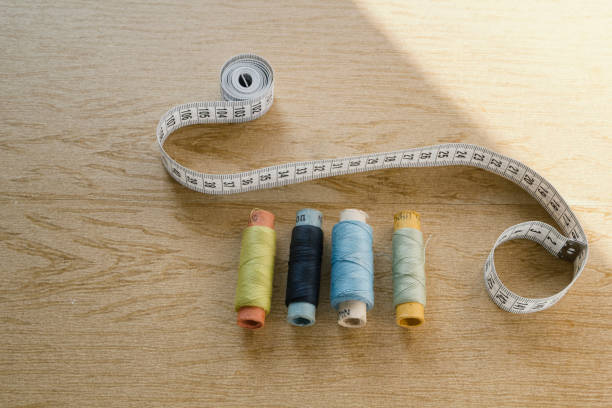 istock Sewing still life - different color cotton thread spools, thimble, needle, measuring tape 842423234