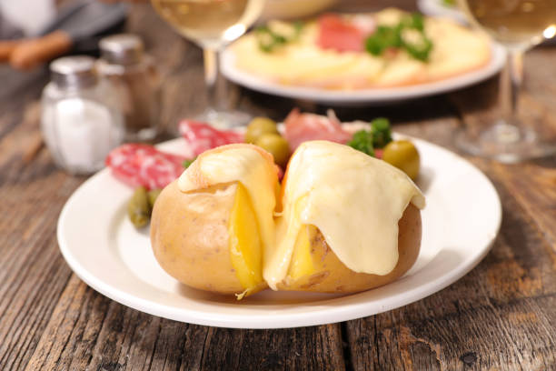 раклетт сыр плавления на картофель - raclette cheese стоковые фото и изображения
