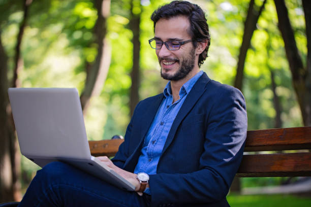 istock Gentleman works on laptop in park 842425938