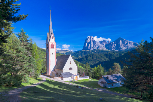 Aerial view of church Cerkev Sv. Ane and church house in Tunjice near Kamnik, Slovenia. Popular cycling and pilgrimage destination. Famous healing center is nearby. Kamnik alps in the background with stormy clouds.