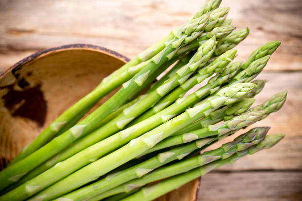 istock Asparagus on the wooden background. 842429826