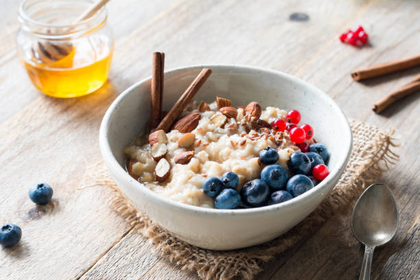 ciotola di porridge di farina d'avena con frutta, noci e cannella in ciotola - almond bowl ceramic food foto e immagini stock