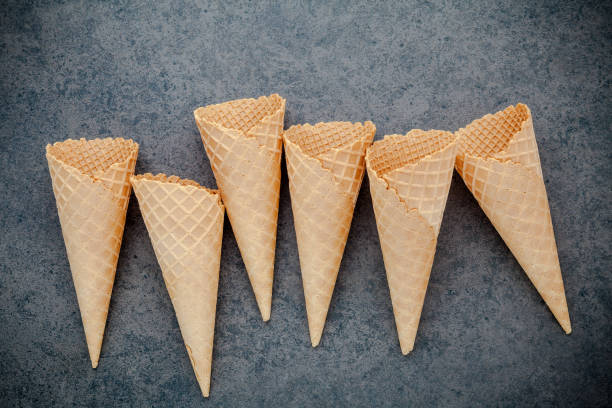 istock Flat lay ice cream cones collection on dark stone background . Blank crispy ice cream cone with copy space for sweets menu design. 842434576