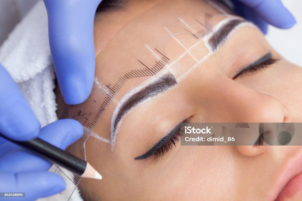 Maquillage permanent pour les sourcils de belle femme avec des sourcils épais dans un salon de beauté. - Photo de Microblading libre de droits