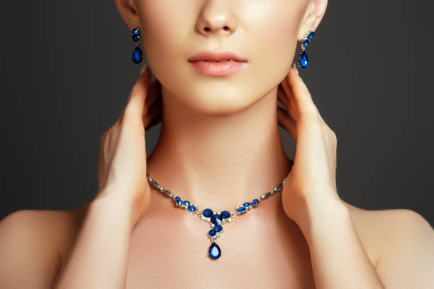 Beautiful woman with a sapphire necklace. Fashion concept Elegant fashionable woman with jewelry. Beautiful woman with a sapphire necklace. Beauty young model with a diamond pendant on a gray background. Jewellery and accessories. Beauty and fashion concept blue saphire stock pictures, royalty-free photos & images