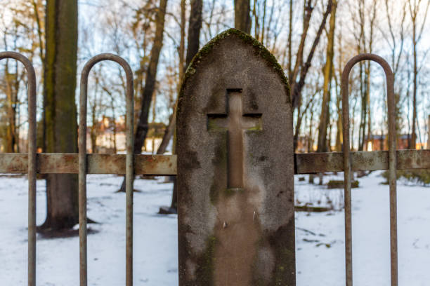 Christian cemetery fence with a pillar and a cross