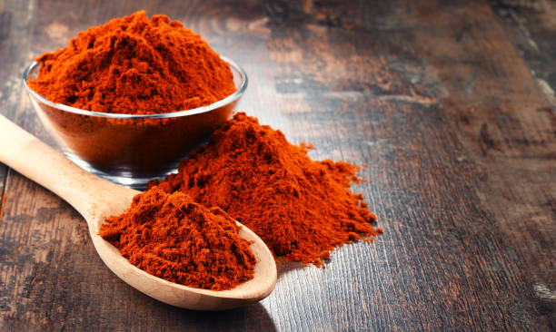 Composition with bowl of chili powder on wooden table Composition with bowl of chili powder on wooden table. cayenne powder photos stock pictures, royalty-free photos & images