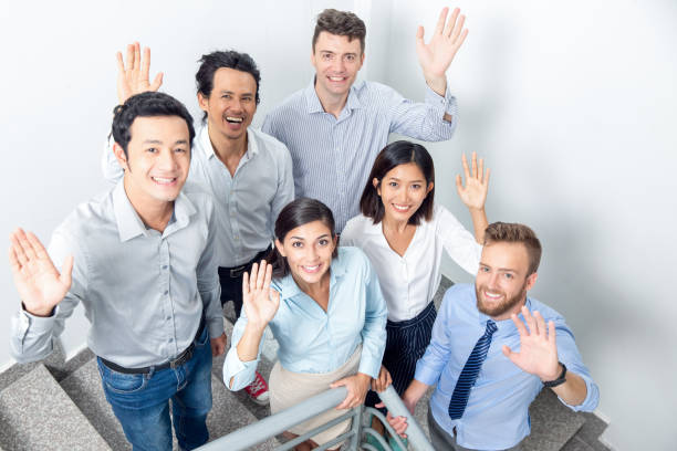 istock Joyful Business Team Waving on Office Stairway 842447058