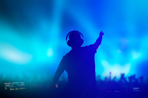 Charismatic disc jockey at the turntable. Charismatic disc jockey. Club, disco DJ playing and mixing music for crowd people. dance & electronic music stock pictures, royalty-free photos & images