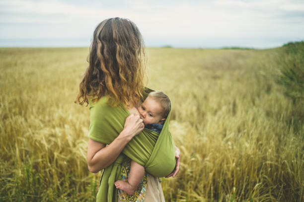 Mother breastfeeding baby in field