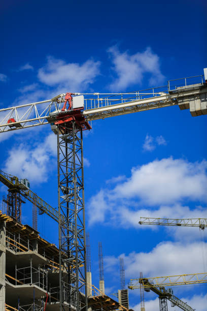 istock Construction concept. A new building under construction against the sky. Blue background. New urban city. Machinery, cranes and builders on scaffolding. Heavy industry and safety at work 842448754