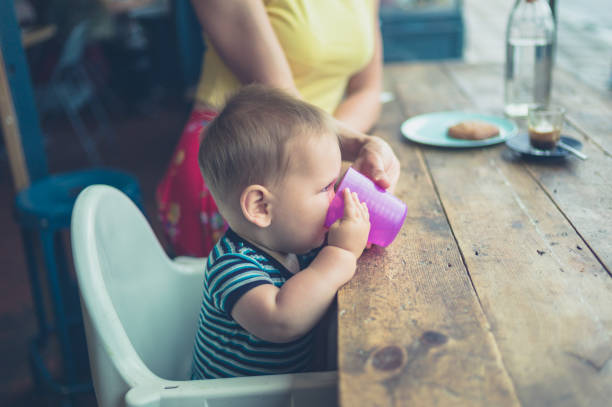 madre e bambino al bar vicino alla finestra - baby cup foto e immagini stock