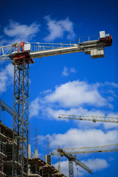 istock Construction concept. A new building under construction against the sky. Blue background. New urban city. Machinery, cranes and builders on scaffolding. Heavy industry and safety at work 842449462