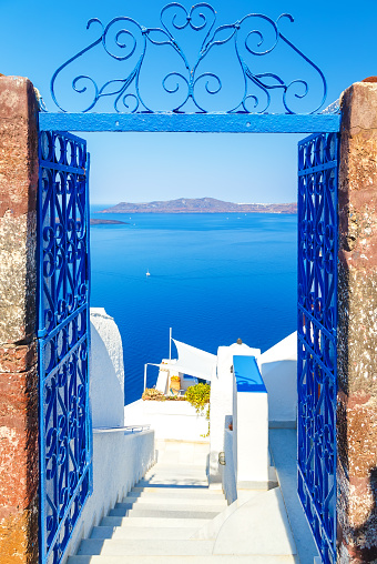 View to the sea and Volcano through a door, from Fira the capital of Santorini island in Greece