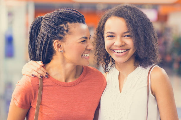 istock Two Smiling Black Girls Embracing in Shopping Mall 842451002