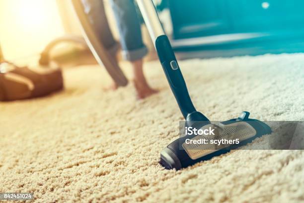 Woman Using A Vacuum Cleaner While Cleaning Carpet In The House Stock Photo - Download Image Now