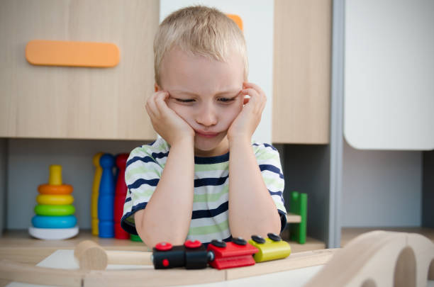 istock Bored sad little boy sitting at table 842452068