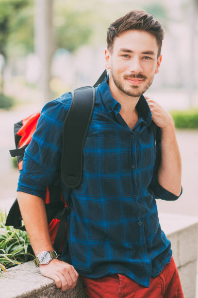 istock Positive Handsome Traveler Sitting on Flowerbed 842452560