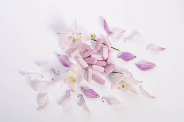 istock Alternative medicine tablets with flowers and petals on table 842453948