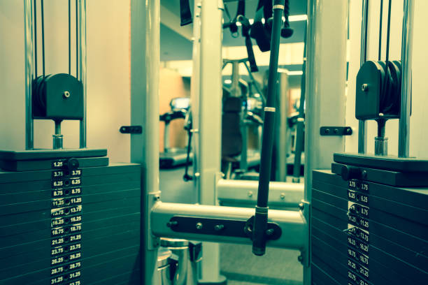 Stacked steel - metal plates in the weight training exercise machine in the indoor gym. Close up view of iron stacked weight plates of workout machine gym.