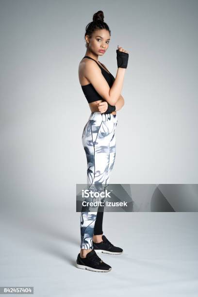 Side View Of Afro American Young Woman In Sports Wear Studio Shot Stock Photo - Download Image Now