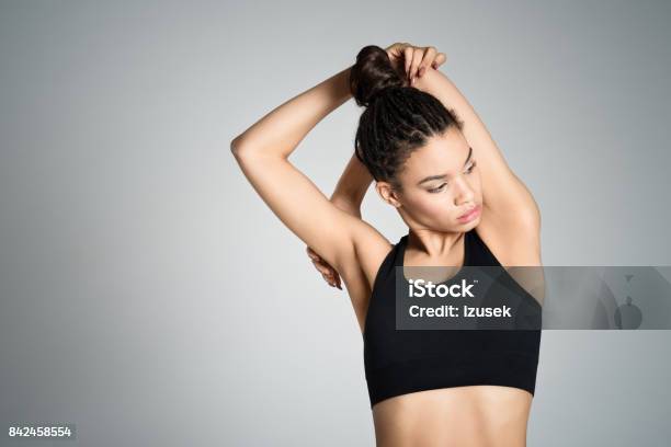 Attractive Fit Young Woman Stretching Her Arms Stock Photo - Download Image Now - Arms Raised, Sports Bra, Studio Shot