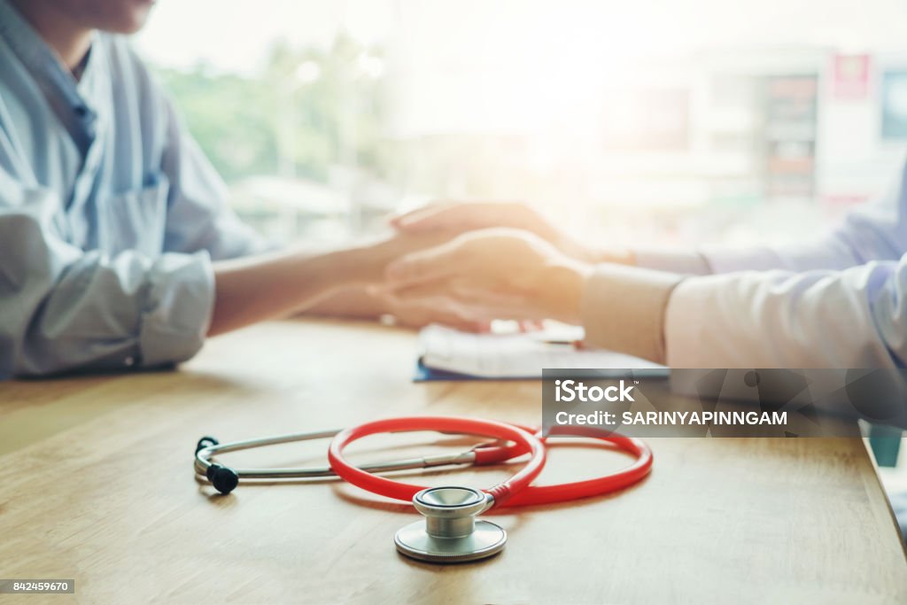 Doctor holding hands for comforting and care patient Doctor Stock Photo
