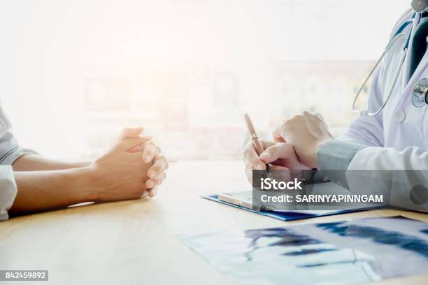 Doctors And Patients Sit And Talk At The Table Near The Window In The Hospital Doctors And Patients Sit And Talk At The Table Near The Window In The Hospital Stock Photo - Download Image Now