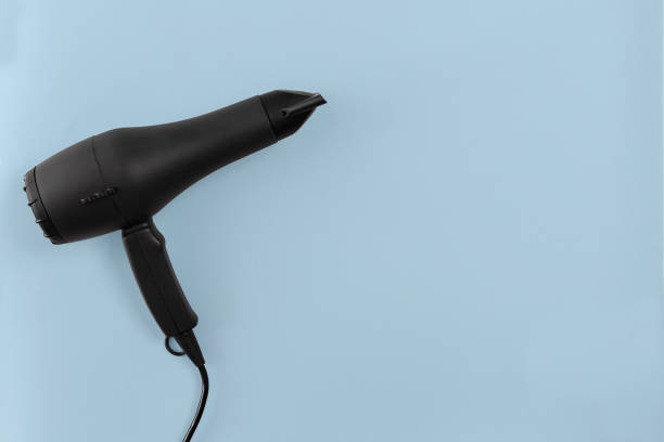istock Black hair dryer on blue paper background 842460710
