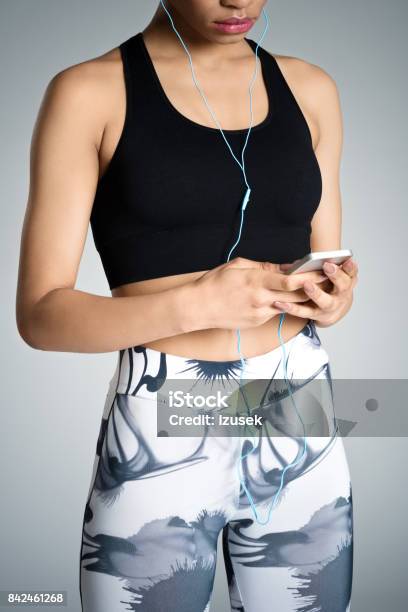 Fitness Young Woman Using Smart Phone Studio Shot Stock Photo - Download Image Now - 16-17 Years, Abdomen, Adult