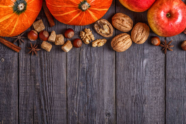 istock Wooden background with pumpkin, apples, nuts and spices. 842462998