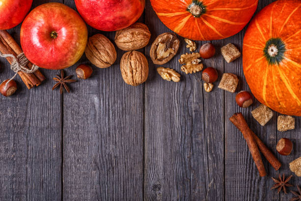 istock Wooden background with pumpkin, apples, nuts and spices. 842463030
