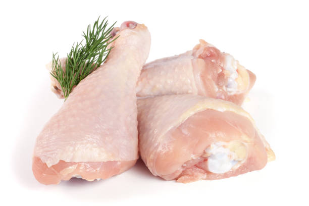 istock Three raw chicken drumsticks with a sprig of dill isolated on white background 842463338