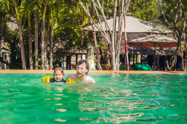 istock Young cheerful father and son in a swimming pool 842465920