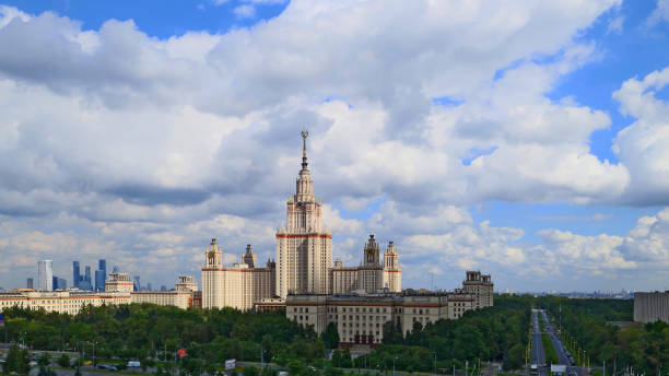 istock Wide angle panoramic landscape view of dramatic clouds over the sunny summer campus of Lomonosov Moscow State University under blue sky 842469290