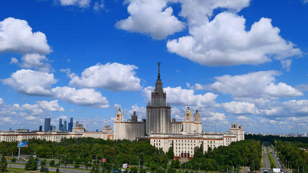 istock Wide angle panoramic landscape view of dramatic clouds over the sunny summer campus of Lomonosov Moscow State University under blue sky 842469294