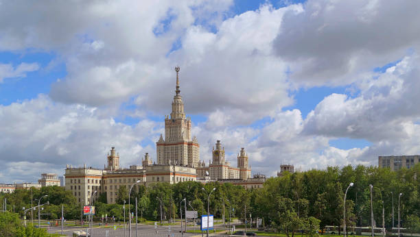 istock Wide angle panoramic landscape view of dramatic clouds over the sunny summer campus of Lomonosov Moscow State University under blue sky 842469312