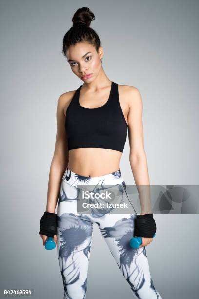 Attractive Young Woman In Sports Wear Holding Dumbbell Weights Stock Photo - Download Image Now