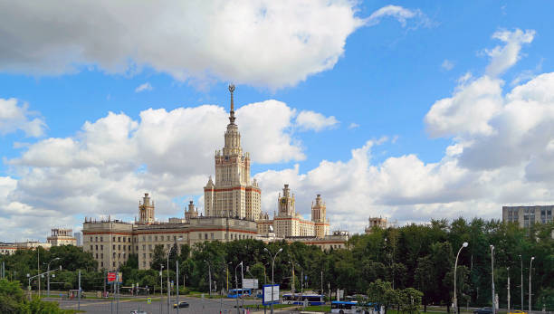 istock Wide angle panoramic landscape view of dramatic clouds over the sunny summer campus of Lomonosov Moscow State University under blue sky 842469662
