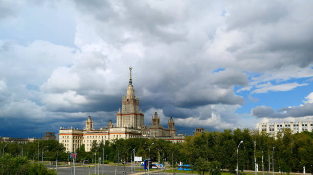 istock Wide angle panoramic landscape view of dramatic clouds over the sunny summer campus of Lomonosov Moscow State University under blue sky 842469674