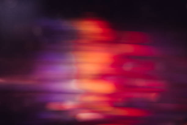 Abstract picture of defocused light motion blur. Glowing urban background, sparkle shiny purple, orange and red lines wallpaper, night city leds bokeh