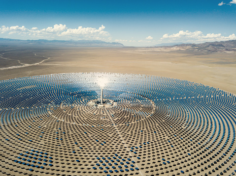 Aerial view from a drone down to large solar thermal power station in the dry desert landscape to the horizon. Nevada, USA.