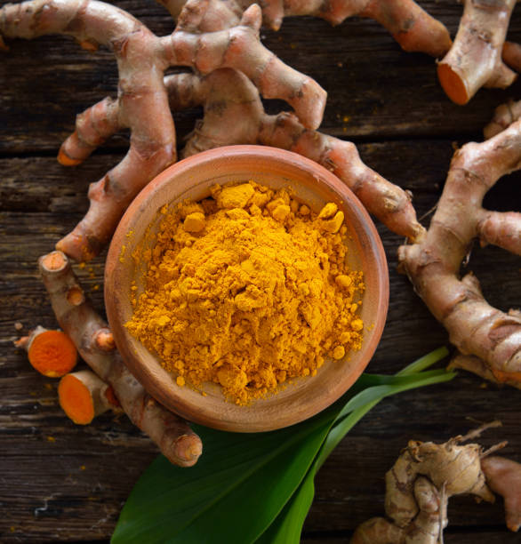 istock Turmeric powder on wooden background 842475396