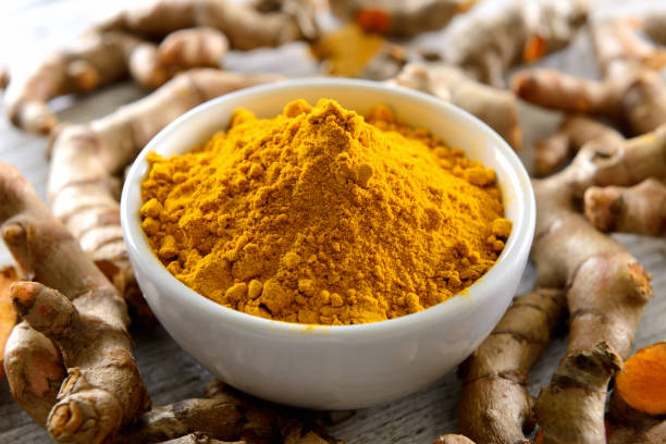 istock Turmeric powder and turmeric capsules on wooden background 842475444
