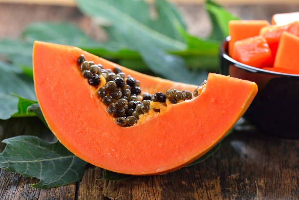 fetta di papaia su legno - papaya foto e immagini stock