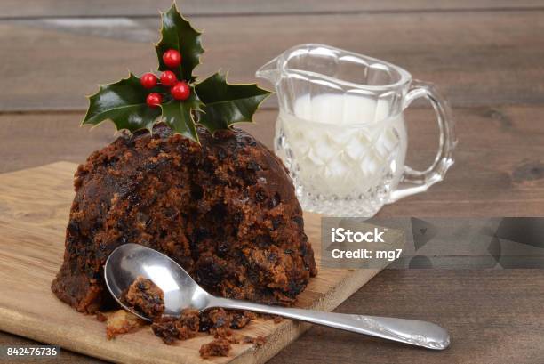 Christmas Pudding On A Cutting Board With Cream Stock Photo - Download Image Now - Berry, Brandy, Cake