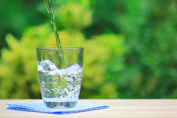 istock Closeup Glass of water on table nature background 842477410